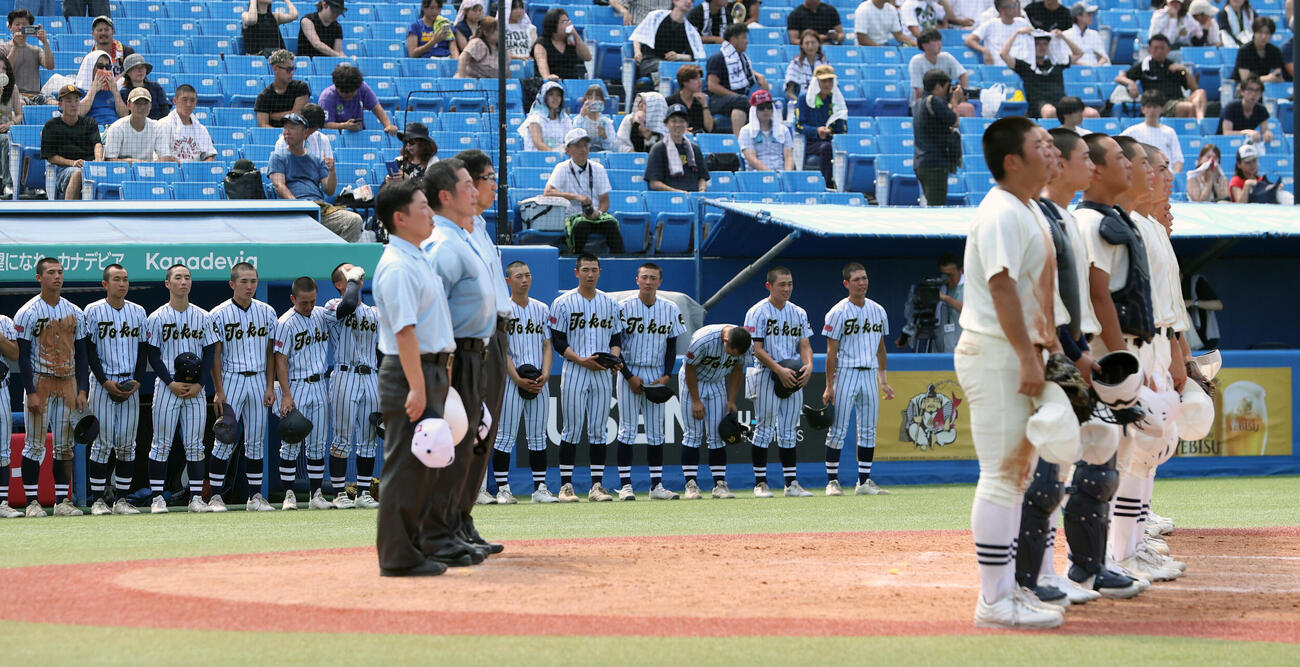 校歌を歌う日大三ナイン、後方は敗れて涙を流す東海大菅生ナイン（撮影・柴田隆二）