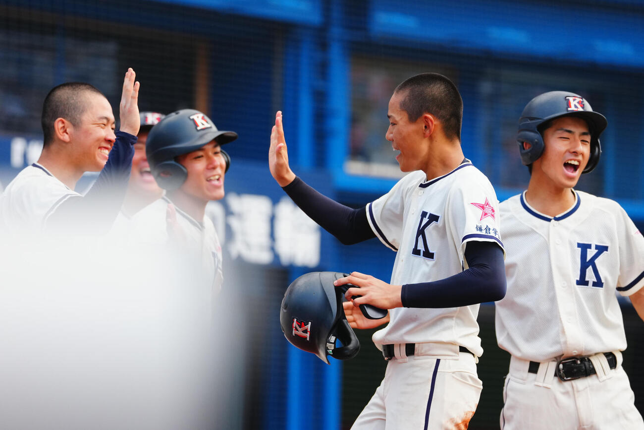 桐光学園対鎌倉学園　5回裏の攻撃を終え適時打を放った鎌倉学園・小杉祐太（右から2人目）はナインと笑顔でタッチを交わす（撮影・垰建太）