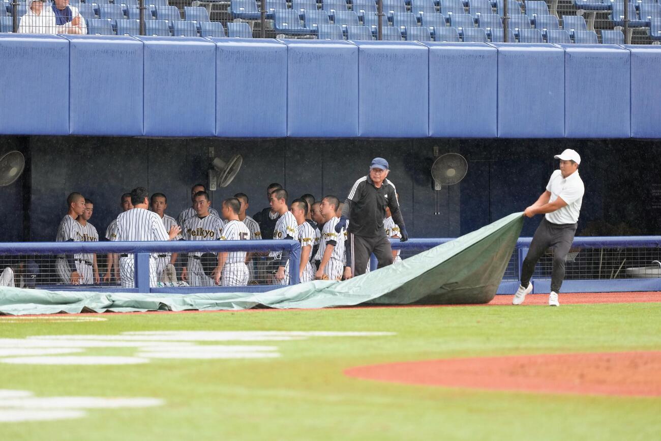 帝京長岡対日本文理　3回裏、雨が激しくなり、試合が一時中断、ベンチで集まる帝京長岡の選手ら（撮影・足立雅史）