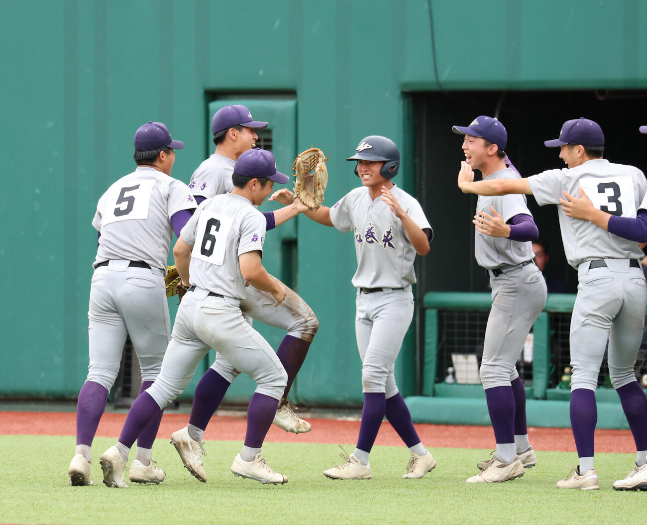 花巻東対盛岡大附　7回表、高野橋纏の打球を本塁に送球した久保村冠太（左から2人目）を出迎える花巻東ナイン（撮影・増田悦実）