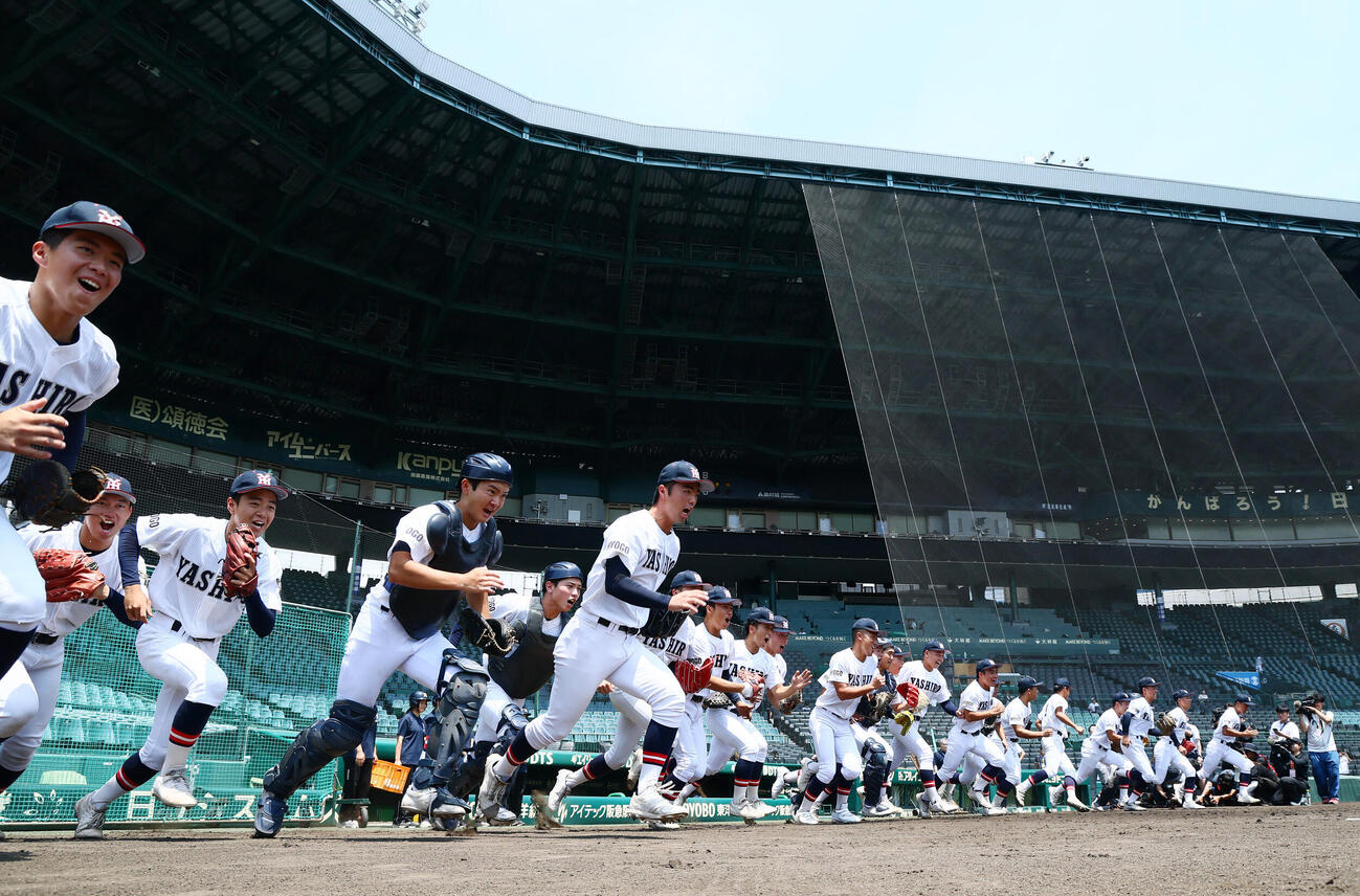 甲子園練習が始まり一斉にグラウンドへ駆け出す社ナイン（撮影・加藤哉）