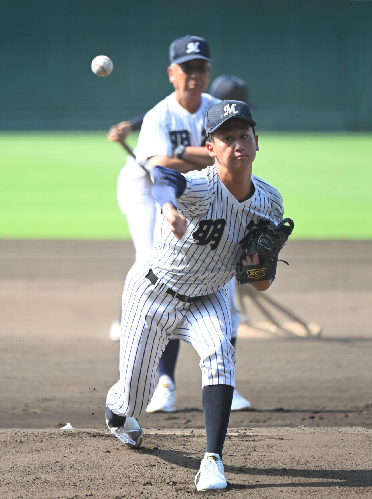 甲子園練習で投球する明徳義塾・田宮諒太郎、後方は馬淵史郎監督k（撮影・和賀正仁）