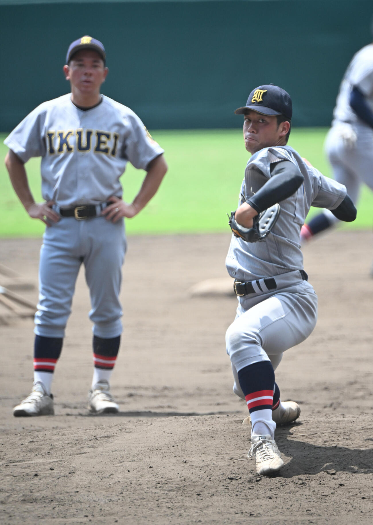 甲子園のマウンドで投球する仙台育英・梶井湊斗、左は須江航監督（撮影・和賀正仁）