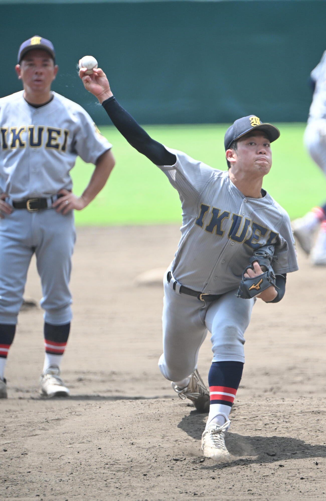 甲子園のマウンドで投球する仙台育英・梶井湊斗、左は須江航監督（撮影・和賀正仁）