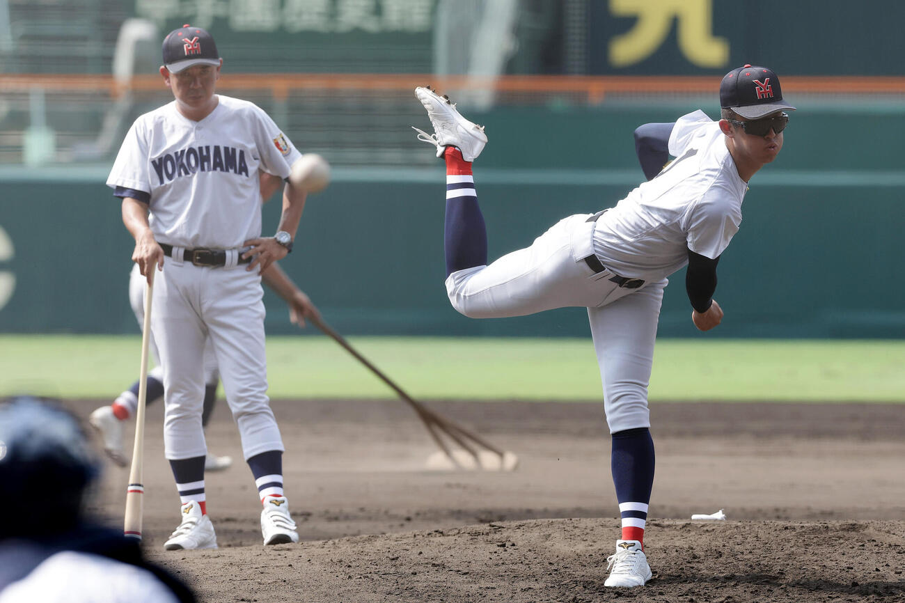 甲子園球場のマウンドで投球練習する横浜・織田翔希。左は見守る村田浩明監督（撮影・前田充）