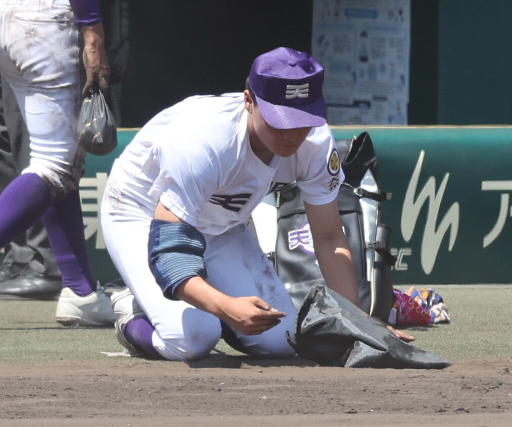 天理対健大高崎　決勝進出を逃した天理長尾亮大は甲子園の土を拾う（撮影・西尾就之）