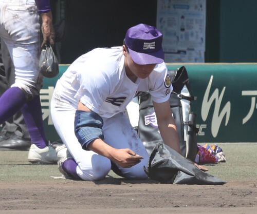 天理対健大高崎 決勝進出を逃した天理・長尾亮大は甲子園の土を拾う(撮影・西尾就之)