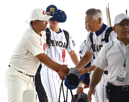 甲子園球場に入る智弁和歌山・中谷仁監督(左)と健大高崎・青柳博文監督は握手を交わして健闘を誓い合う(撮影・上田博志)