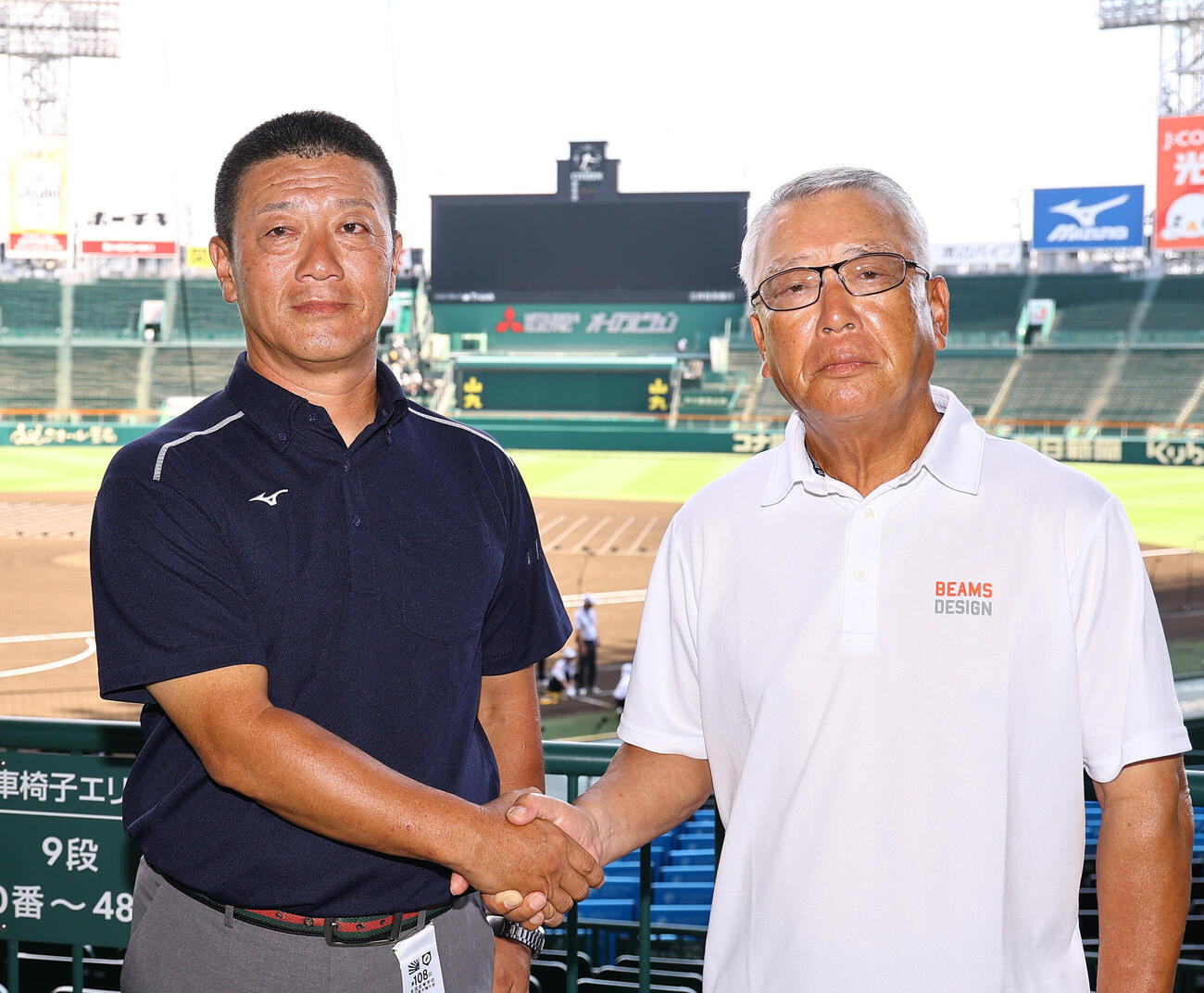 握手を交わす明徳義塾・馬淵史郎監督（右）と日南学園・金川豪一郎監督（撮影・上田博志）