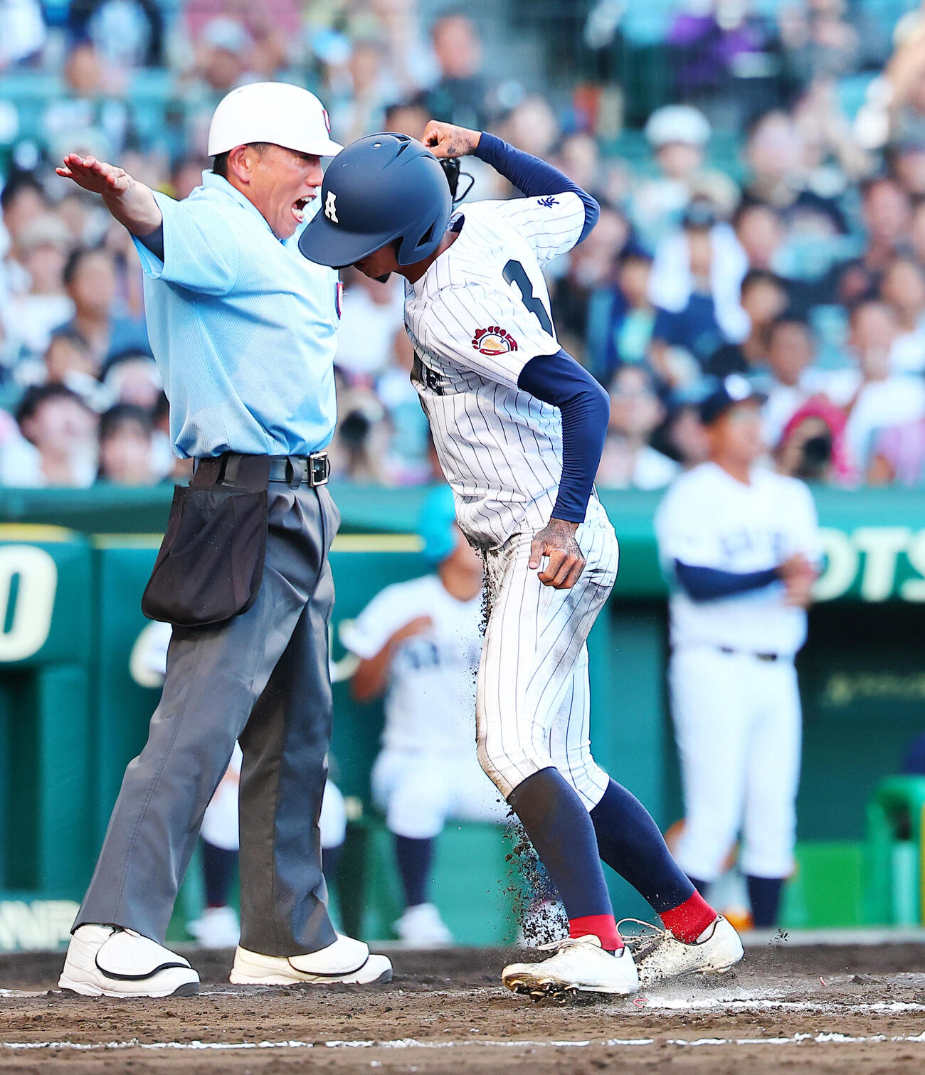 有明対立命館宇治　7回表有明2死二、三塁、永田晴輝の2点適時安打で生還し喜ぶ新谷遼（撮影・野上伸悟）