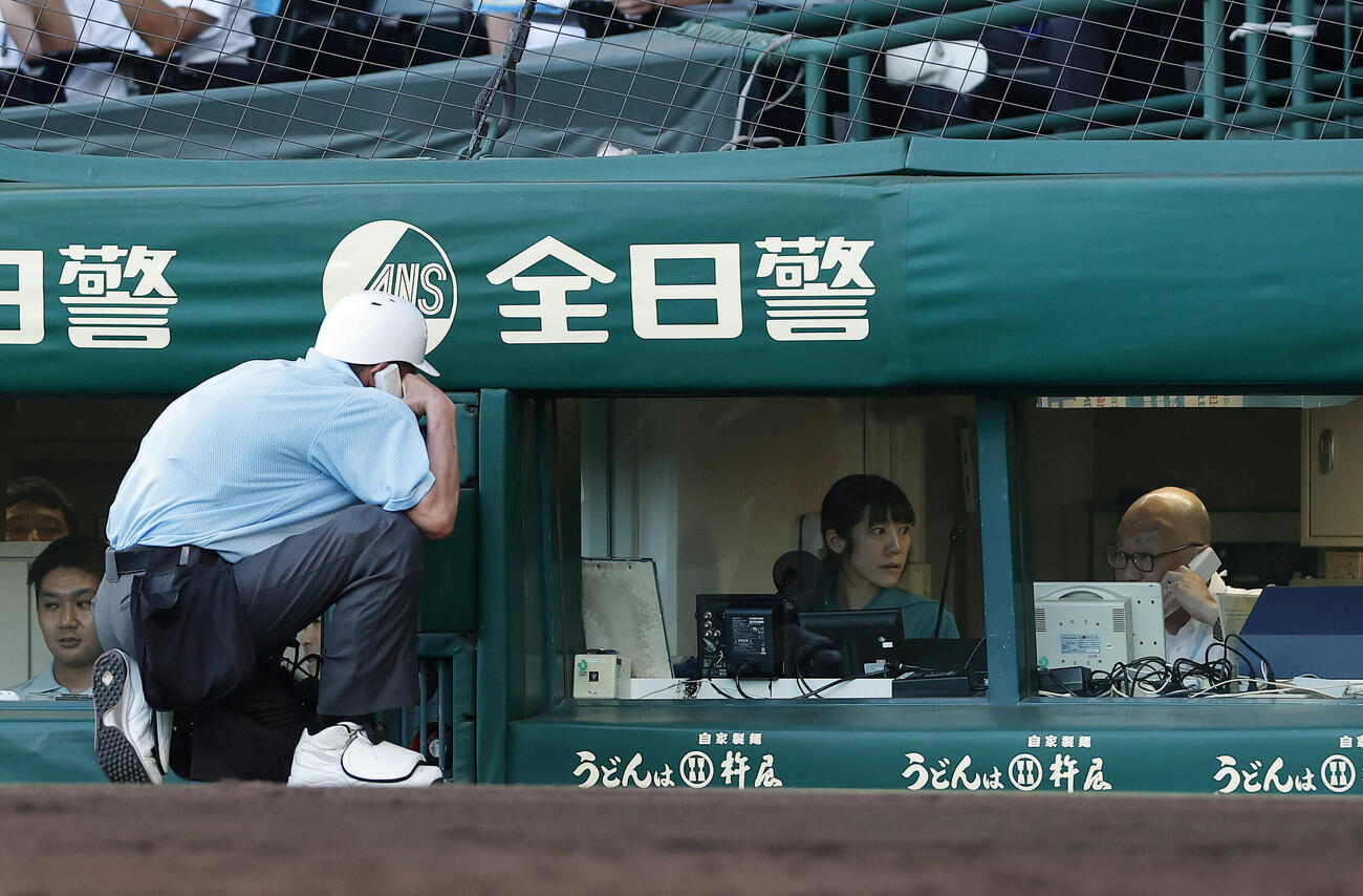 有明対立命館宇治　7回表有明2死一塁、永田晴輝の二盗アウト判定に対してビデオ検証を行う永井球審（左）ら（撮影・前田充）