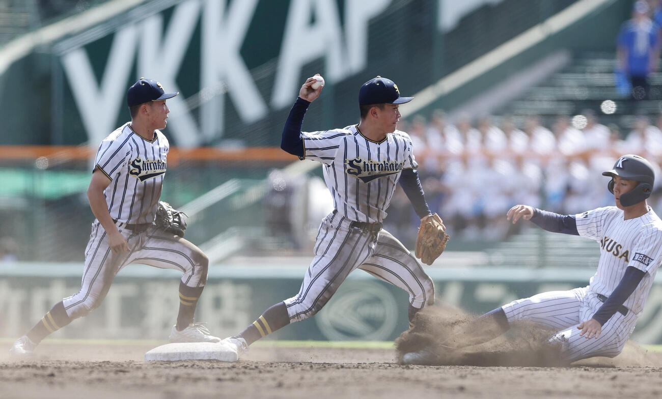 東日本国際大昌平対白樺学園　8回表東日本国際大昌平1死一塁、金沢匠良を二ゴロ併殺に仕留める遊撃手後藤健（中央）と二塁手金井瀬那（左）（撮影・前田充）