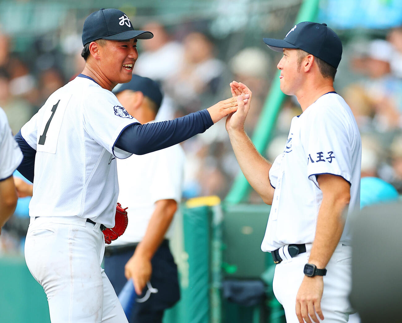 八王子実践対鳴門渦潮　3回裏を終え河本ロバート監督（右）に迎えられる八王子実践先発の塚原翔太（撮影・野上伸悟）