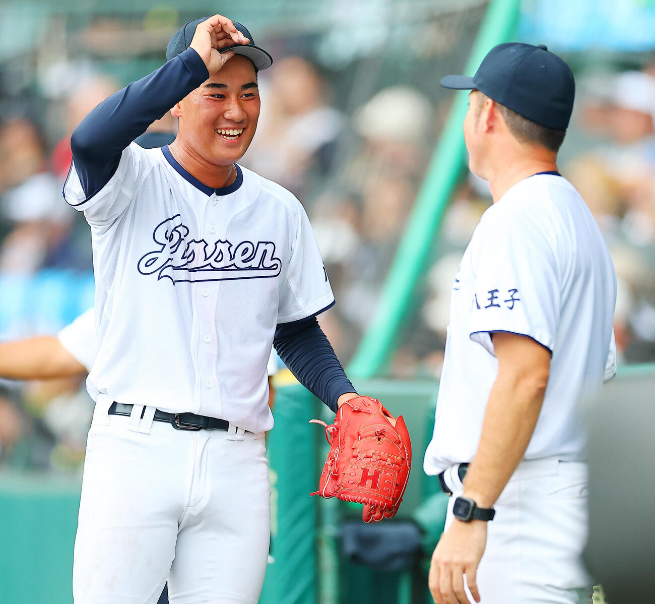 八王子実践対鳴門渦潮　3回裏を終え河本ロバート監督（右）に迎えられる八王子実践先発の塚原翔太（撮影・野上伸悟）