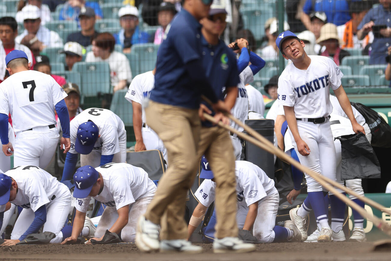 敦賀気比対横手　敦賀気比に敗れ、甲子園球場の砂を集める佐藤宙斗（右）ら横手の選手たち（撮影・河田真司）