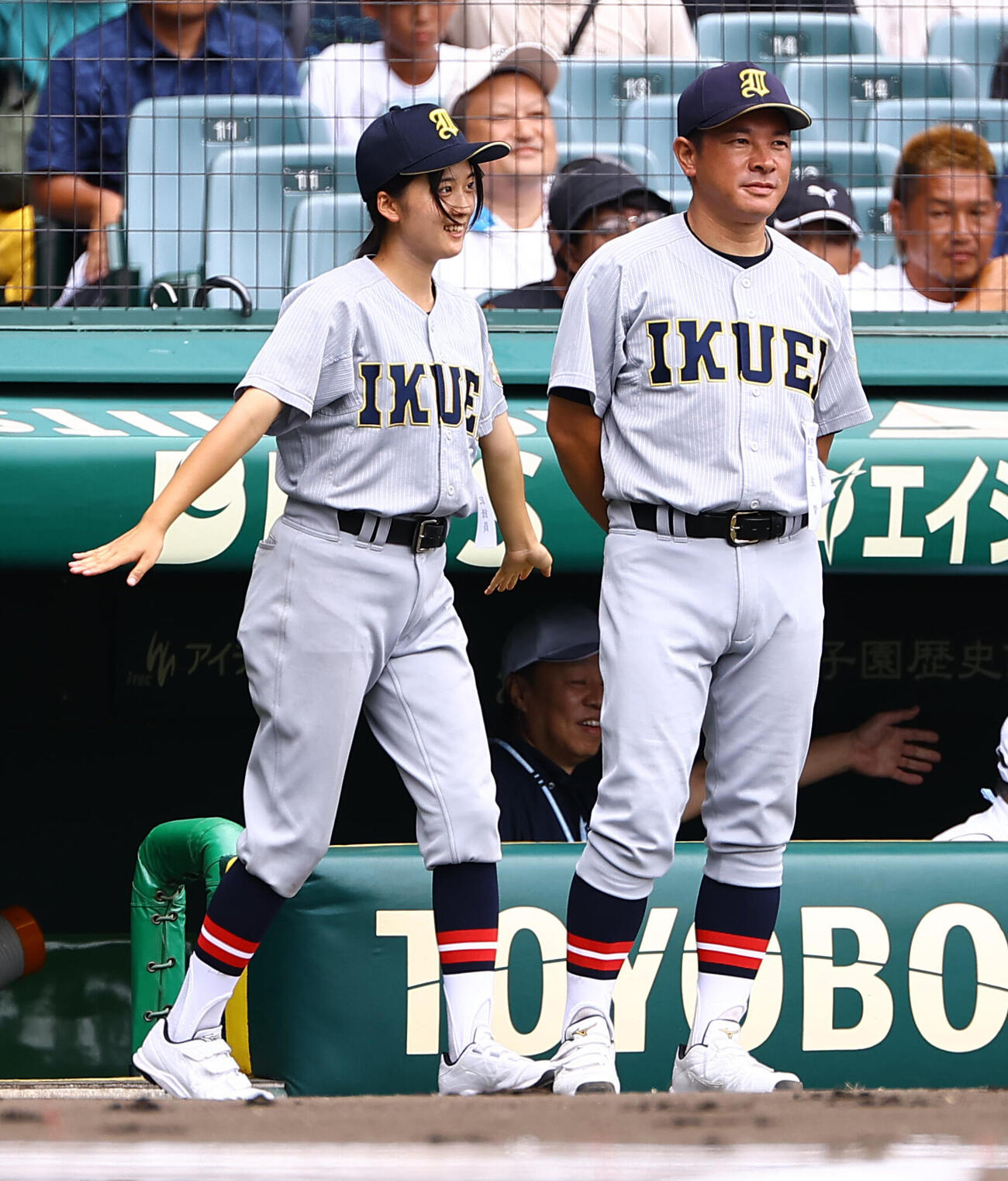 花咲徳栄対仙台育英　始球式をベンチ外で見ようとする仙台育英・星よつはマネージャーは飛行機ポーズでベンチを飛び出す（撮影・上田博志）