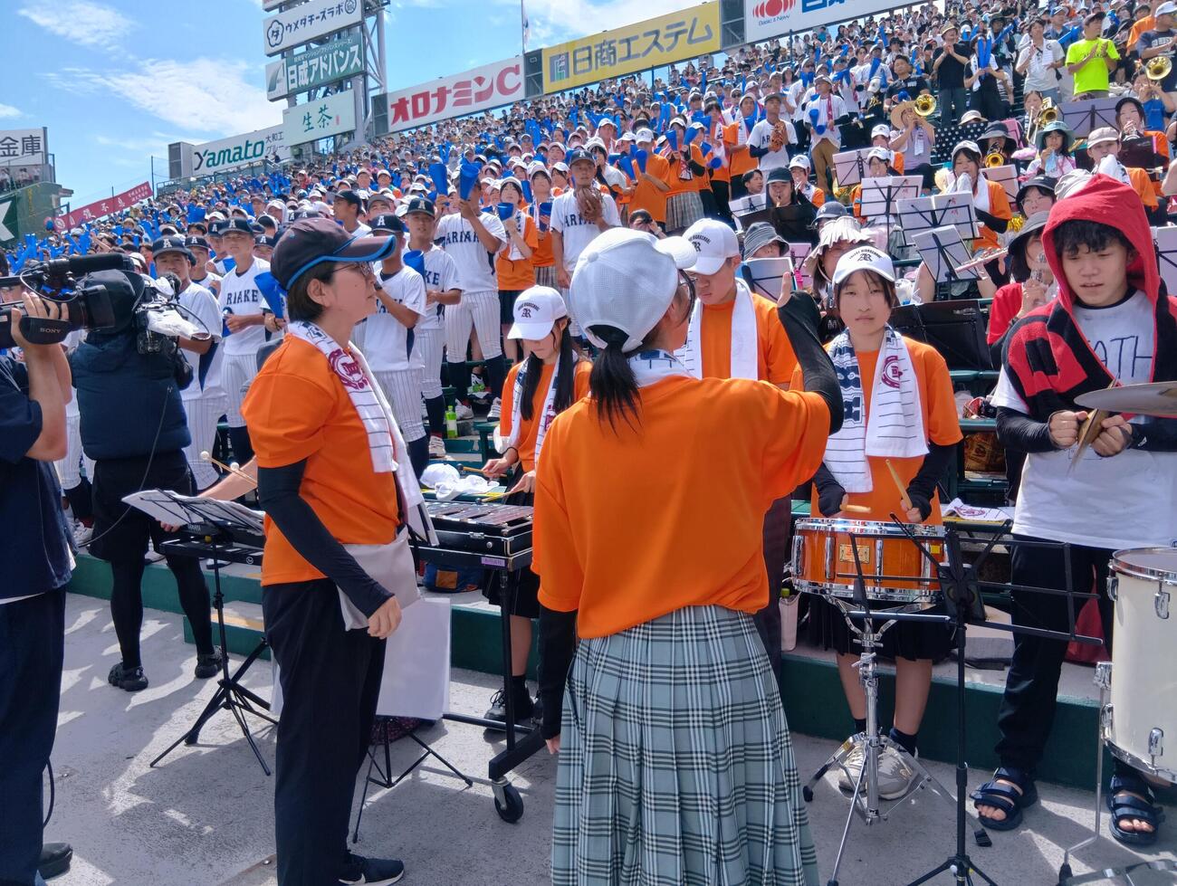 全国高校野球選手権　有明の演奏をリードする吹奏楽部の石川優子顧問（左）