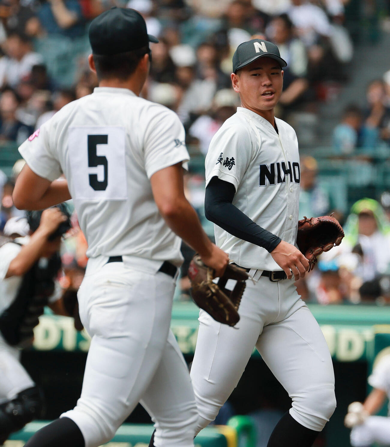 長崎日大対有明　初回を投げ終えベンチに引き揚げる長崎日大エース古賀友樹（右）（撮影・上山淳一）