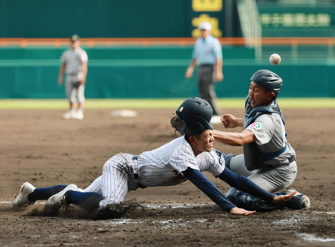 青森山田対東日本国際大昌平　5回裏東日本国際大昌平無死一塁、小内壱晟の適時二塁打で生還する一走新井凜（手前）。捕手沖野悠雅（撮影・上山淳一）