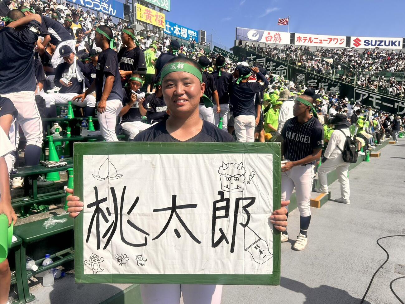「桃太郎」を歌い始めるときに使うボードを持つ岡山学芸館の竹田（撮影・平山連）