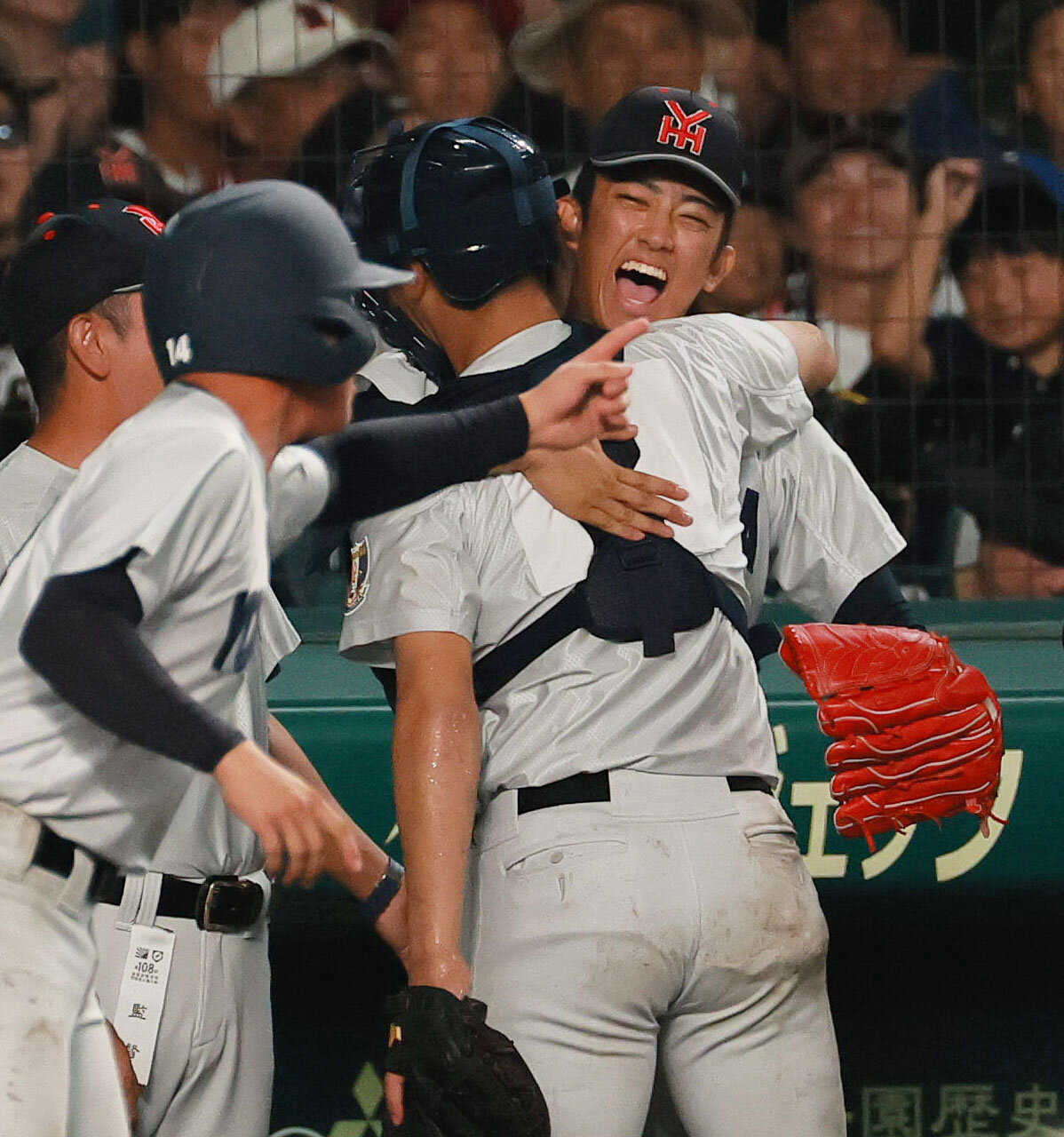 横浜対日南学園　7回裏、無死満塁のピンチを無失点で抑えた織田翔希（右）は捕手脇山魁音とベンチ前で抱き合って喜ぶ（撮影・上山淳一）
