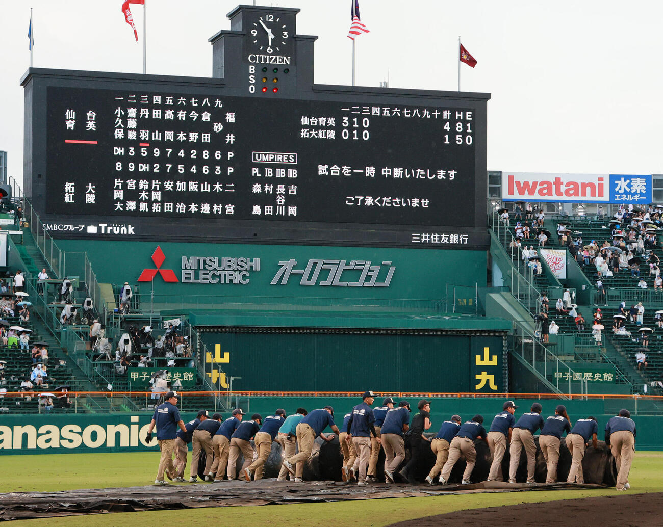 仙台育英対拓大紅陵　雨でグラウンドシートをかぶせる阪神園芸の職員たち（撮影・上山淳一）