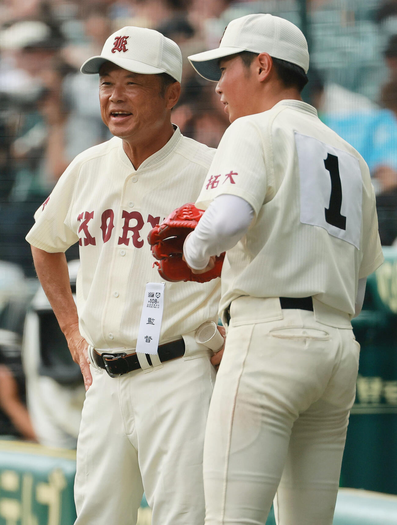仙台育英対拓大紅陵　3回表を投げ終えた拓大紅陵エース二宮楽（手前）はベンチ前で拓大紅陵の坂巻展行監督の話を聞く（撮影・上山淳一）