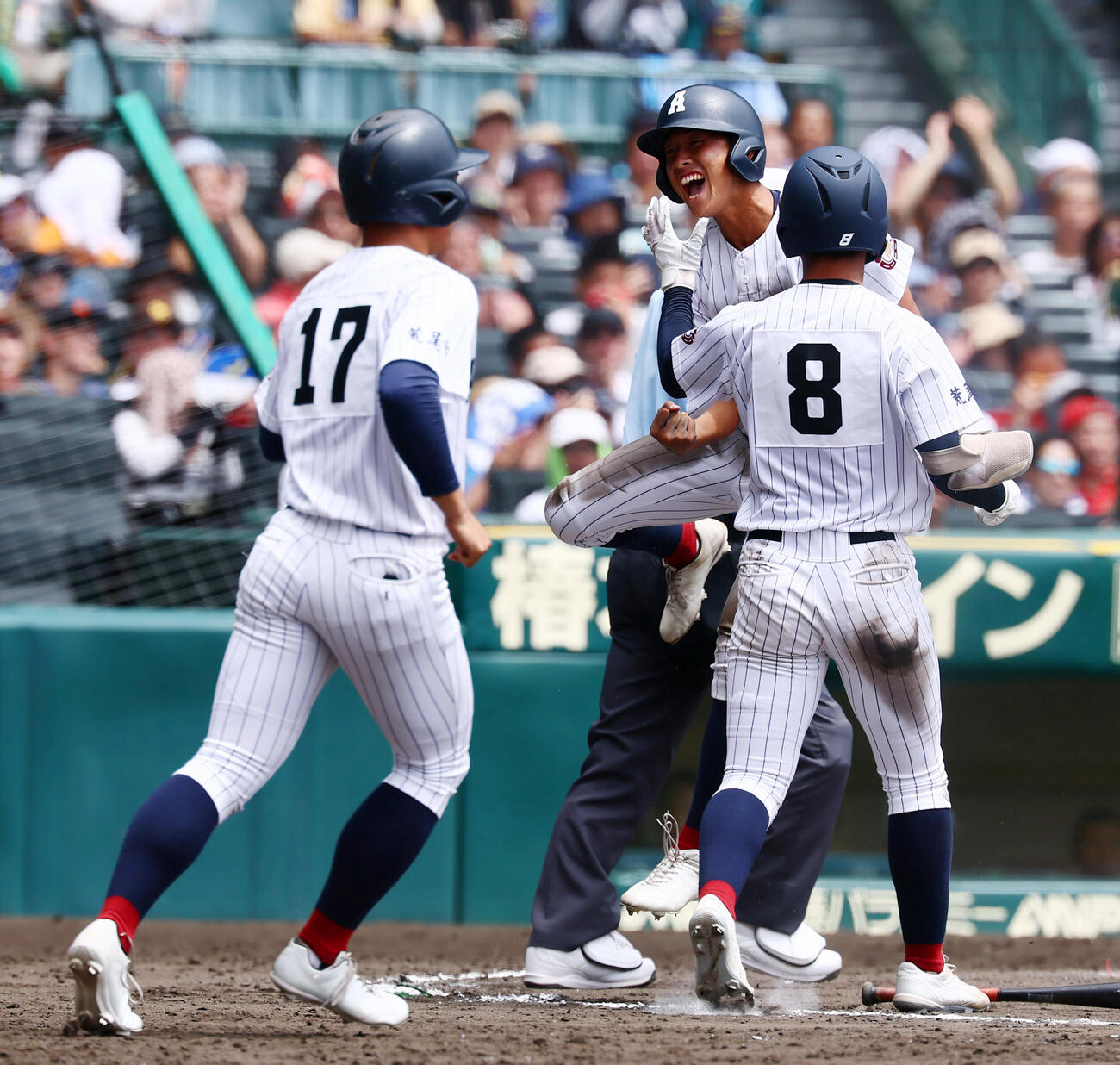 有明対東日本国際大昌平　8回表有明2死二、三塁、栄井彰の右前2点適時打で生還し笑顔でナインとタッチする二走代走空見大愛（撮影・加藤哉）