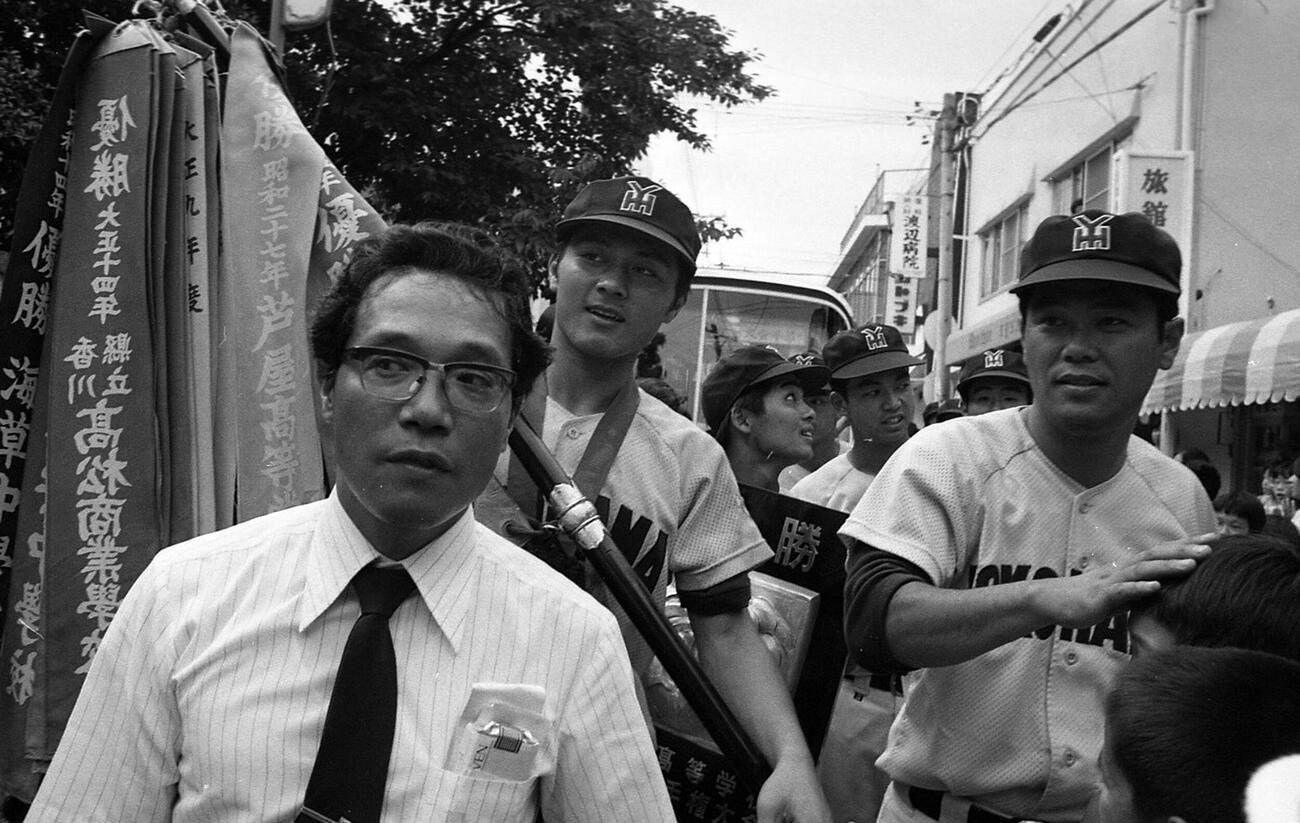 80年8月、深紅の優勝旗を持って宿舎に入る横浜・愛甲猛主将（中央）と渡辺監督