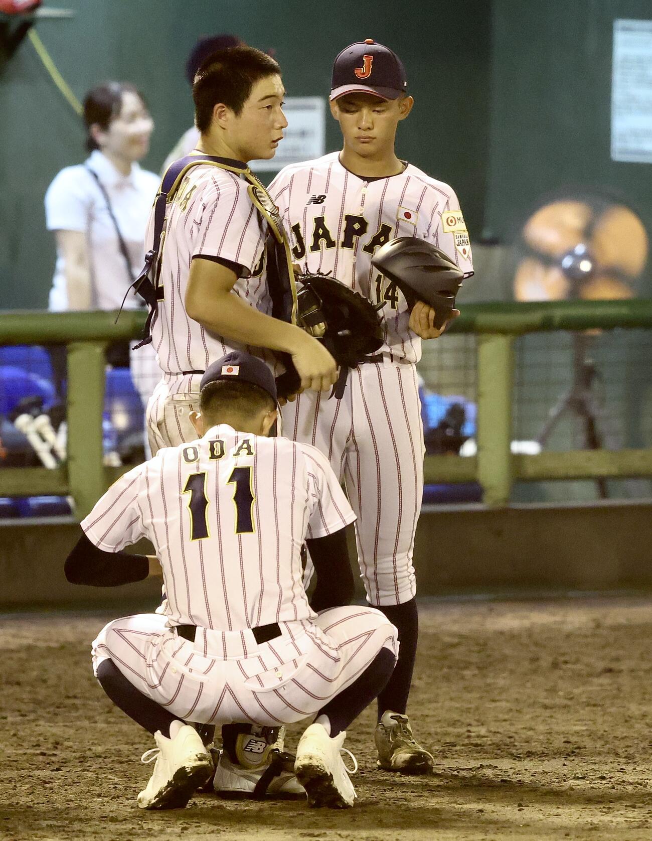 U18高校日本代表対早大　8回表を終え、山田凜虎（中央）の防具の取り付けを手伝う、U18高校日本代表の織田翔希（手前）と前田侑大（撮影・河田真司）