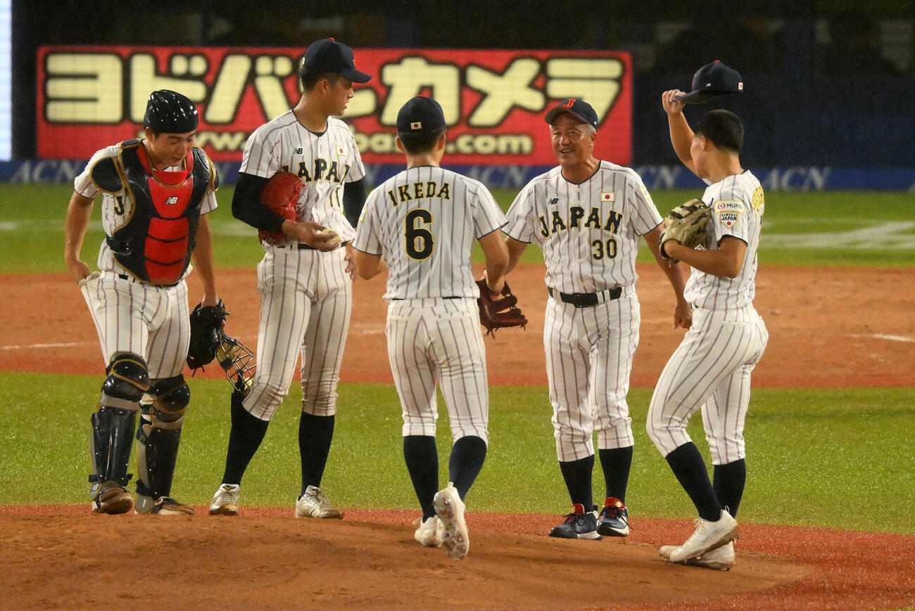 大学日本代表対高校日本代表　2回表、高校日本代表・岡田龍生監督（左から4人目）は織田翔希（同2人目）に話す（撮影・滝沢徹郎）