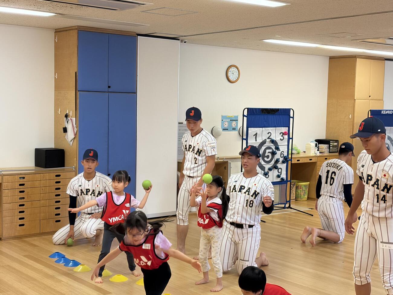 YMCAキャナルコート保育園を訪問し、園児たちにボール投げを教える高校日本代表の投手陣（撮影・保坂淑子）