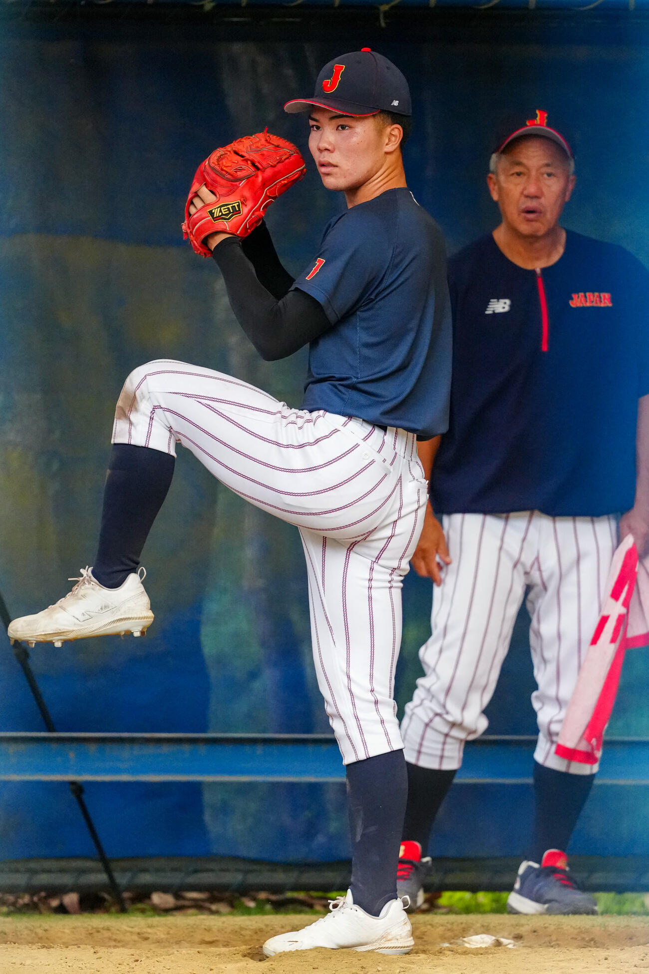 岡田龍生監督（後方）が見つめる中、ブルペン投球する福島陽奈汰（撮影・江口和貴）