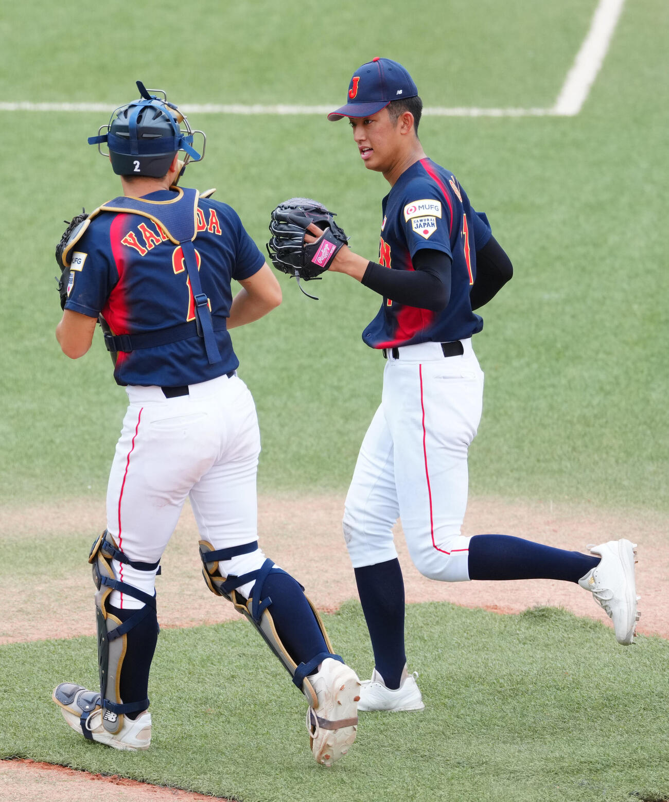 高校日本代表対明大　1回裏終了後、高校日本代表捕手の山田凜虎（左）と引き揚げる先発の織田翔希（撮影・江口和貴）