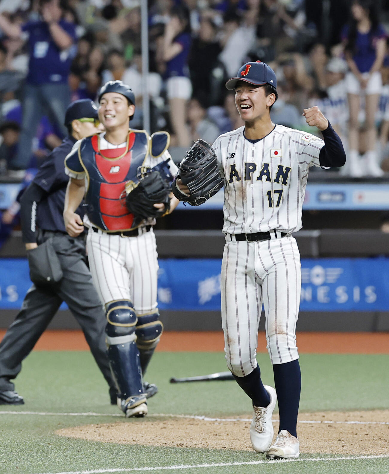 台湾に勝利し、ガッツポーズする萬谷（右）。奥は山田（共同）