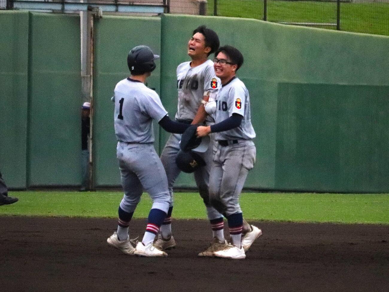 東海大相模対慶応　延長10回タイブレーク、2死満塁からサヨナラの中前適時打を放ち、涙を流しチームメートに支えられる慶応・渡辺英亜（中央）（撮影・保坂淑子）