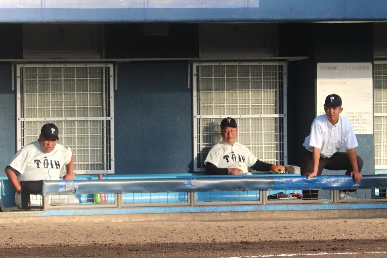 高校野球大阪大会準々決勝　試合前ノックをベンチから見つめる、大阪桐蔭・小川翔平記録員（右）と同校の西谷浩一監督（左）、有友茂史部長（中）