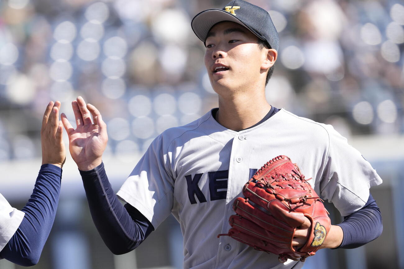 佐野日大対慶応　1回表終了後タッチを交わす慶応・湯本琢心（撮影・小島史椰）