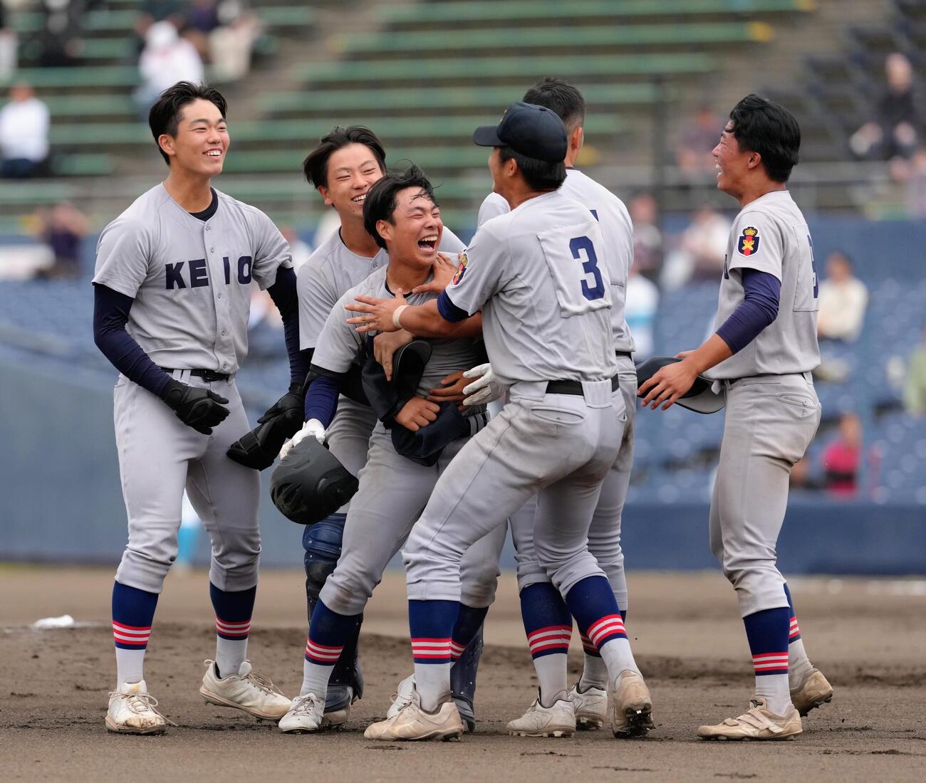 山梨学院対慶応　タイブレークの10回裏慶応1死一、二塁、矢口翔大（中央）はサヨナラ適時打を放ち祝福される（撮影・足立雅史）