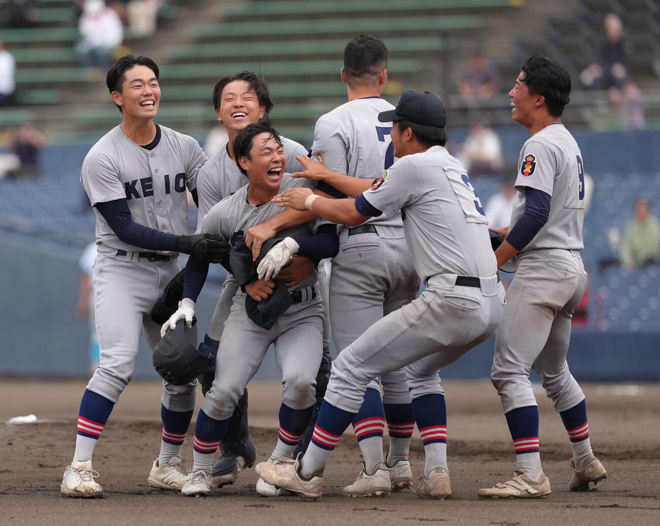 山梨学院対慶応　タイブレークの10回裏慶応1死、1死二塁、矢口翔大（左から3人目）はサヨナラ適時打を放ちナインの祝福に笑顔を見せる（撮影・足立雅史）