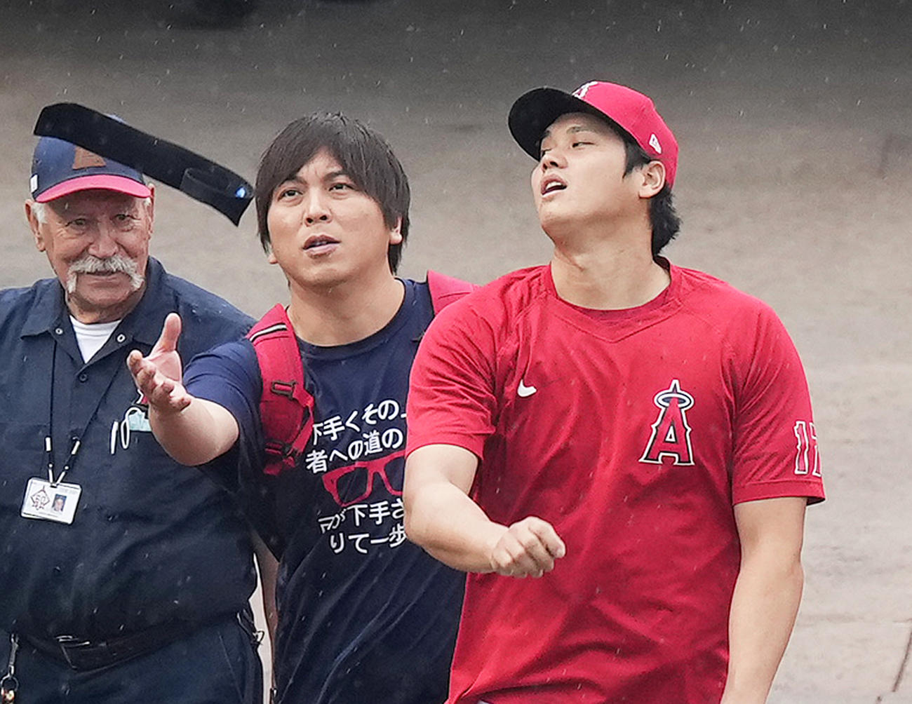 9月24日、マリナーズ戦で試合前、バンドを上に向かって投げるエンゼルス大谷。後方を歩く水原通訳は、不意打ちにもナイスキャッチする（撮影・菅敏）