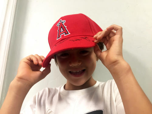 大谷らエンゼルスの3選手からのサイン入り帽子をかぶるマック君