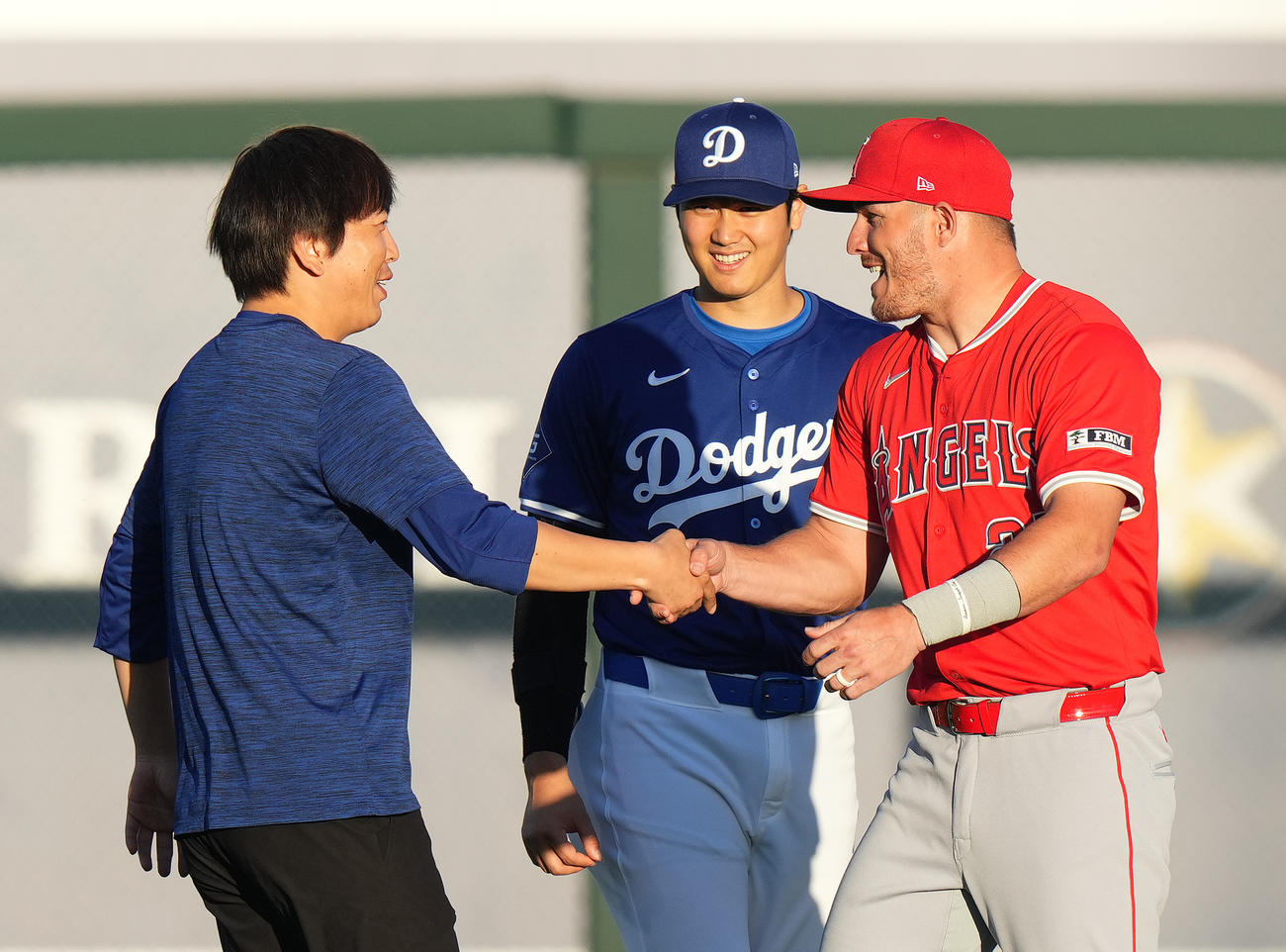 ３月５日、ドジャース対エンゼルス　試合前、エンゼルス・トラウト（右）と再会し、握手であいさつする水原通訳。中央はドジャース大谷（撮影・菅敏）
