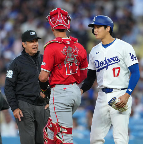 ドジャース対エンゼルス　3回裏途中、エンゼルスのオホッピーに声をかけ審判に笑顔で注意を受ける大谷（撮影・横山健太）