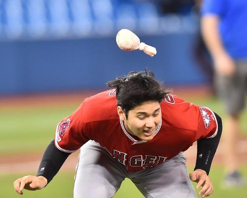 ブルージェイズ対エンゼルス　ブルージェイズに勝利し、ナインとハイタッチをするエンゼルス大谷翔平は、飛んできたロージンを慌てて避ける＝２０１９年６月19日
