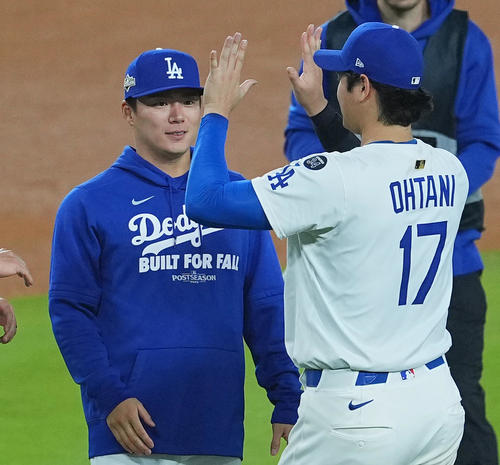 ワールドシリーズ進出を決め、山本（左）とタッチをするドジャース大谷（撮影・菅敏）