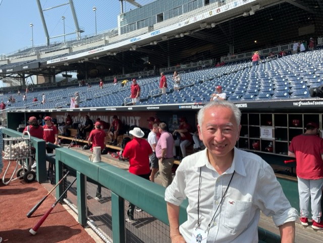 カレッジワールドシリーズ試合前のベンチ風景と福島氏（手前）