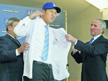 ドジャースの入団記者会見でユニホームを着る黒田投手(中央)(共同)