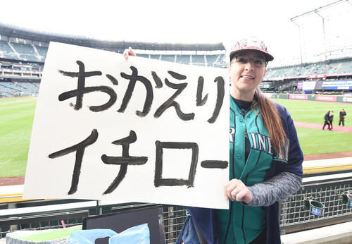 イチローがマリナーズに復帰し、日本語で書いたボードを手に笑顔を見せるイチメーターのエイミー・フランツさん（撮影・菅敏）