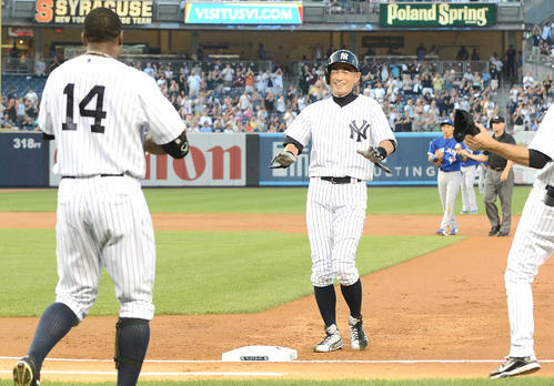 ヤンキース対ブルージェイズ　１回、日米通算４０００本安打を達成したイチローは、ベンチを飛び出し祝福に向かうナインに照れ笑いを見せる（撮影は２０１３年８月２１日）